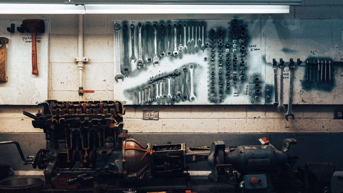 Small petrol engine repair on a workshop bench — carburettor problems are the most common fix