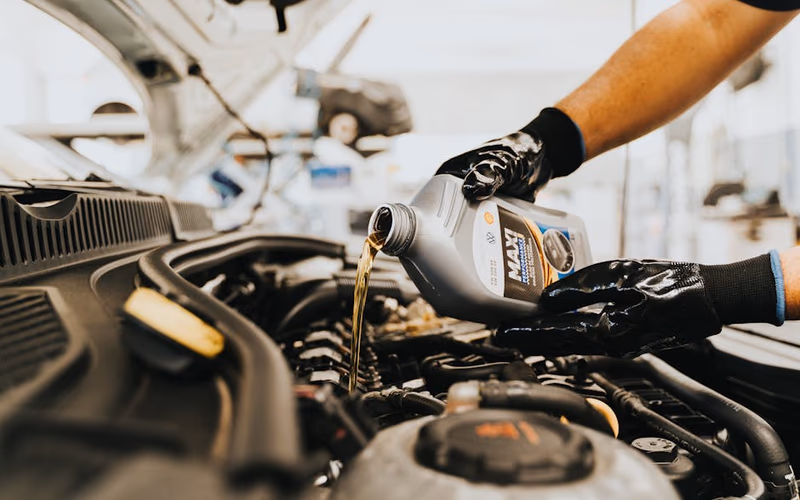 Spark plug being checked and cleaned on a petrol strimmer engine